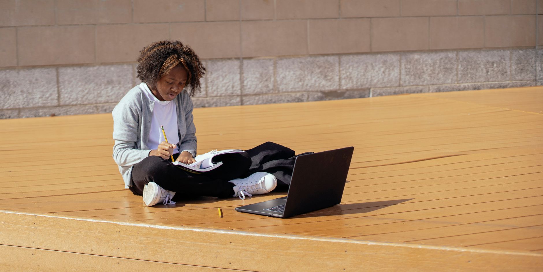 Learner studying a new language online with headphones and a laptop